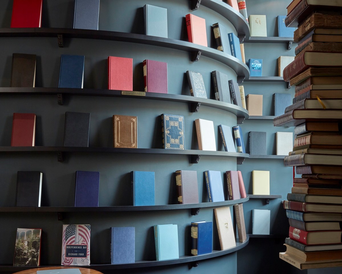 A wooden bookshelf filled with a diverse collection of books, showcasing various colors and sizes.